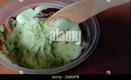 La foto è una foto di gelato al gusto di avocado in una tazza con sfondo nero Foto Stock