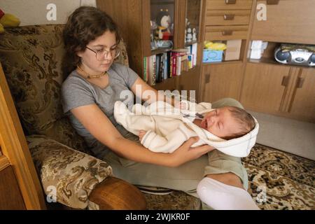sorella che tiene tra le braccia un fratello appena nato. famiglia Foto Stock