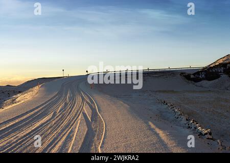Tracce di pneumatici nella neve sulla strada maggiore, Reykjavik, Islanda Foto Stock