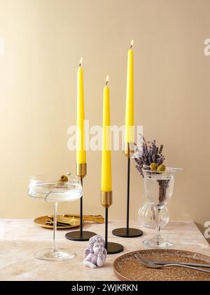 le candele sono posizionate sul tavolo con candelabri in metallo alti. festivi t Foto Stock