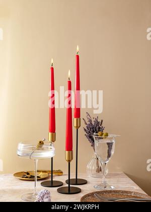 le candele sono posizionate sul tavolo con candelabri in metallo alti. festivi t Foto Stock