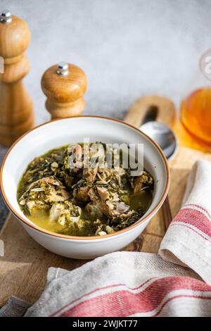 Piatto tradizionale georgiano Chakapuli nella ciotola servito sul tavolo con un bicchiere di vino ambrato Foto Stock