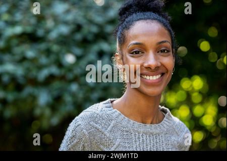 Allegra giovane donna adulta che guarda la fotocamera mentre si trova all'aperto Foto Stock