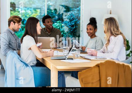 Gli uomini d'affari discutono di un progetto mentre erano riuniti in ufficio Foto Stock