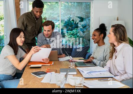 Uomini d'affari che discutono sul lavoro cartaceo mentre sono seduti in ufficio Foto Stock