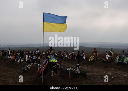 Vista delle tombe dei soldati caduti delle forze armate ucraine nel cimitero di Zaporizhzhia. In due anni di guerra in Ucraina dall'invasione russa del 24 febbraio 2022, decine di migliaia di soldati e civili hanno perso la vita. Il numero esatto di vittime è impossibile da stabilire, con entrambe le parti che forniscono poche informazioni sulle loro perdite, per evitare di minare il morale tra le truppe e il pubblico più ampio. Mentre l'invasione su vasta scala della Russia si aggira verso il traguardo dei due anni e apparentemente senza fine a breve. Foto Stock