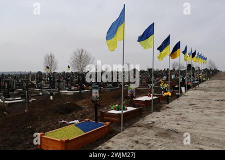 Vista delle tombe dei soldati caduti delle forze armate ucraine nel cimitero di Zaporizhzhia. In due anni di guerra in Ucraina dall'invasione russa del 24 febbraio 2022, decine di migliaia di soldati e civili hanno perso la vita. Il numero esatto di vittime è impossibile da stabilire, con entrambe le parti che forniscono poche informazioni sulle loro perdite, per evitare di minare il morale tra le truppe e il pubblico più ampio. Mentre l'invasione su vasta scala della Russia si aggira verso il traguardo dei due anni e apparentemente senza fine a breve. Foto Stock