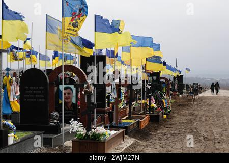 Vista delle tombe dei soldati caduti delle forze armate ucraine nel cimitero di Zaporizhzhia. In due anni di guerra in Ucraina dall'invasione russa del 24 febbraio 2022, decine di migliaia di soldati e civili hanno perso la vita. Il numero esatto di vittime è impossibile da stabilire, con entrambe le parti che forniscono poche informazioni sulle loro perdite, per evitare di minare il morale tra le truppe e il pubblico più ampio. Mentre l'invasione su vasta scala della Russia si aggira verso il traguardo dei due anni e apparentemente senza fine a breve. Foto Stock