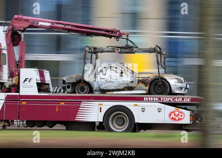 Lipsia, Germania. 16 febbraio 2024. Una BMW Z3 bruciata viene trasportata via su un rimorchio dopo essere stata recuperata dal parcheggio sotterraneo di Augustusplatz. Il dipartimento investigativo sta indagando su un incendio nel parcheggio sotterraneo sotto Augustusplatz di Lipsia. Durante la notte, due auto sono state completamente distrutte nell'incendio e un'altra auto e un furgone sono stati danneggiati. Il parcheggio sotterraneo sul lato dell'Opera rimane chiuso fino a quando un ingegnere strutturale non lo ha ispezionato. Crediti: Jan Woitas/dpa/Alamy Live News Foto Stock