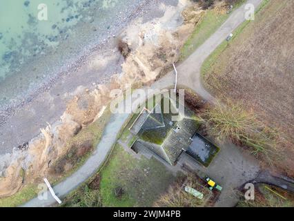 PRODUZIONE - 14 febbraio 2024, Schleswig-Holstein, Lübeck-Travemünde: Veduta delle scogliere e del centro giovanile "Haus Seeblick" dell'organizzazione giovanile "SJD - Die Falken", sulle scogliere di Brodten sul Mar Baltico (drone shot). Il centro giovanile "Haus Seeblick", situato direttamente sulle scogliere di Brodten, è chiuso per bambini e giovani dopo un'altra demolizione. Solo quattro metri si trovano tra un angolo della 'Haus Seeblick' e l'abisso. Alla fine di gennaio, un albero cadde lungo il bordo e lasciò un buco nel sentiero di fronte alla casa. Foto: Marcus Brandt/dpa Foto Stock