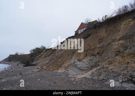 PRODUZIONE - 14 febbraio 2024, Schleswig-Holstein, Lübeck-Travemünde: Veduta della scogliera rotta presso il centro giovanile "Haus Seeblick" dell'organizzazione giovanile "SJD - Die Falken", sulla scogliera nel distretto di Brodten sul Mar Baltico. Il centro giovanile "Haus Seeblick", situato direttamente sulle scogliere di Brodten, è ora chiuso per i bambini e il lavoro giovanile dopo un'altra rottura. Solo quattro metri si trovano tra un angolo della 'Haus Seeblick' e l'abisso. Alla fine di gennaio, un albero cadde lungo il bordo e lasciò un buco nel sentiero di fronte alla casa. Foto: Marcus Brandt/dpa Foto Stock