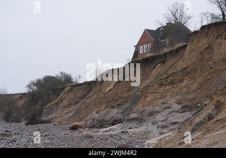 PRODUZIONE - 14 febbraio 2024, Schleswig-Holstein, Lübeck-Travemünde: Veduta della scogliera rotta presso il centro giovanile "Haus Seeblick" dell'organizzazione giovanile "SJD - Die Falken", sulla scogliera nel distretto di Brodten sul Mar Baltico. Il centro giovanile "Haus Seeblick", situato direttamente sulle scogliere di Brodten, è ora chiuso per i bambini e il lavoro giovanile dopo un'altra rottura. Solo quattro metri si trovano tra un angolo della 'Haus Seeblick' e l'abisso. Alla fine di gennaio, un albero cadde lungo il bordo e lasciò un buco nel sentiero di fronte alla casa. Foto: Marcus Brandt/dpa Foto Stock