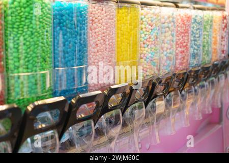 Una vivace esposizione di distributori di caramelle riempiti di una varietà di dolci colorati, che offrono una scelta deliziosa per coloro che amano i dolci Foto Stock