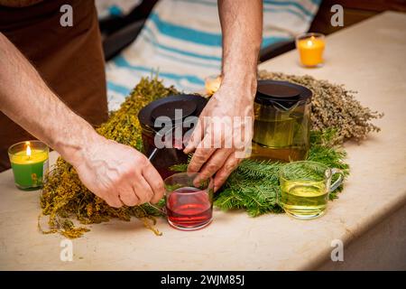 Utilizzando una teiera, qualcuno sta versando un liquido caldo e fumante in una tazza sulla stoviglie erbosa. Potrebbe essere tè, una bevanda alcolica, o una soluzione per Foto Stock