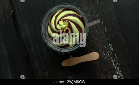 La foto è una foto di gelato al gusto di avocado in una tazza con sfondo nero Foto Stock