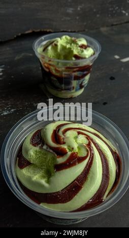 La foto è una foto di gelato al gusto di avocado in una tazza con sfondo nero Foto Stock
