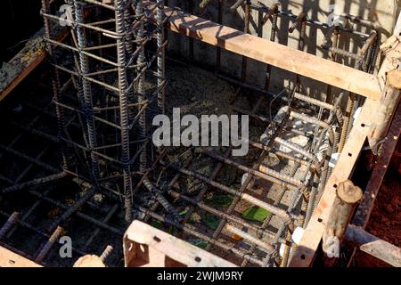 Sede di fondazione di una nuova casa, edificio, dettagli e rinforzi con barre di acciaio e vergella, preparazione per il travaso di cemento. Concetto di costruzione Foto Stock