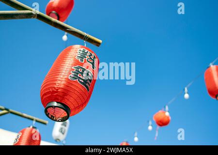 Lanterne rosse giapponesi su sfondo blu del cielo, Giappone (il testo significa cibo) Foto Stock