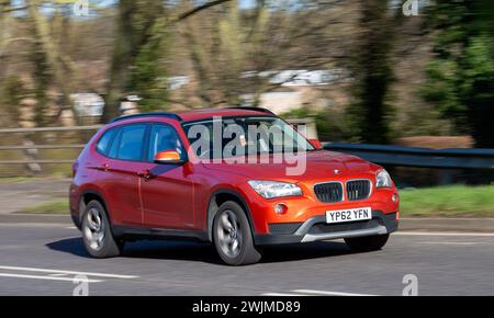 Milton Keynes, UK-13 febbraio 2024: 2012 motore diesel arancione BMW X1 che guida su una strada inglese Foto Stock