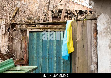 La bandiera dell'Ucraina è appesa al muro di una vecchia casa rotta in Ucraina nel Dnieper Foto Stock