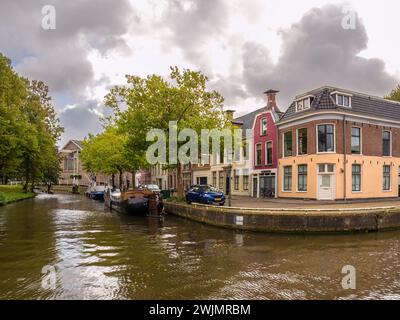 Fila di ville e case lungo la banchina del canale Eebuurt nella città vecchia di Leeuwarden, Frisia, Paesi Bassi Foto Stock