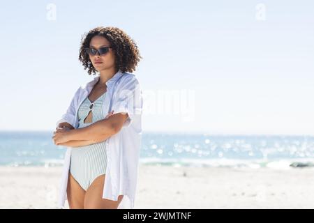 La giovane donna birazziale sta in piedi con sicurezza sulla spiaggia, con spazio di copia inalterato Foto Stock