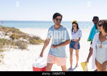 Un gruppo eterogeneo di amici gode di una giornata di sole in spiaggia Foto Stock