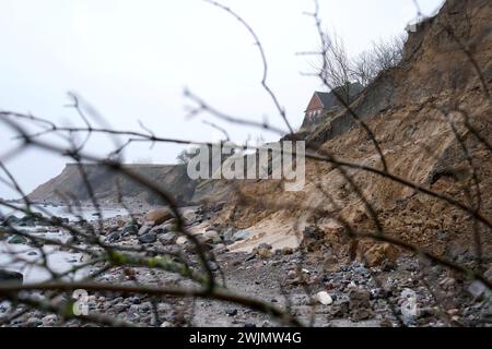 PRODUZIONE - 14 febbraio 2024, Schleswig-Holstein, Lübeck-Travemünde: Veduta delle scogliere nel distretto di Brodten sul Mar Baltico. Il centro giovanile "Haus Seeblick", situato direttamente sulle scogliere di Brodten, è chiuso ai bambini e al lavoro giovanile dopo un altro crollo del bordo. Solo quattro metri si trovano tra un angolo della 'Haus Seeblick' e l'abisso. Alla fine di gennaio, un albero cadde lungo il bordo e lasciò un buco nel sentiero di fronte alla casa. Foto: Marcus Brandt/dpa Foto Stock