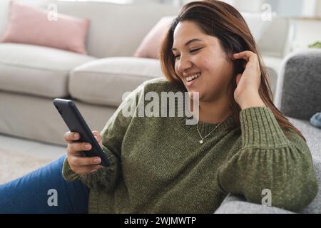Una giovane donna birazziale di grandi dimensioni ama trascorrere il tempo libero a casa Foto Stock