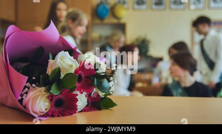 Primo giorno di scuola. I fiori giacciono sul tavolo per celebrare il giorno della scuola. Foto Stock