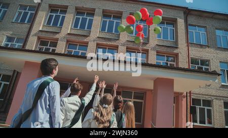 I diplomati delle superiori lanciano palloncini nel cielo. Foto Stock