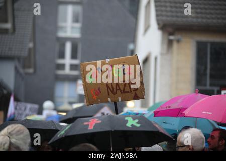 16 febbraio 2024, Renania settentrionale-Vestfalia, Kürten: I partecipanti a una manifestazione contro l'estremismo di destra stanno di fronte al municipio con cartelli con slogan come "No Place for Nazis”. Il comune di Kürten, nella regione Bergisches Land, deve mettere il suo centro comunitario a disposizione dell'AfD per un evento di festa questo venerdì. Secondo un annuncio del tribunale di venerdì, il comune aveva cercato di impedire l'evento populista del venerdì delle ceneri organizzato dall'associazione distrettuale Rhein-Berg dell'AfD. Foto: Sascha Thelen/dpa Foto Stock