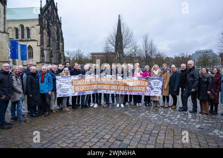 16 febbraio 2024, Renania settentrionale-Vestfalia, Münster: In una manifestazione contro l'AfD e l'estremismo di destra, quasi 30 sindaci della regione di Münsterland hanno uno striscione che recita: "Sindaci Münsterland contro l'estremismo di destra e per la democrazia”. I politici locali, iniziati dall'alleanza "Keinen Meter", protestano contro il ricevimento dell'AfD nel municipio storico. Foto: Guido Kirchner/dpa Foto Stock