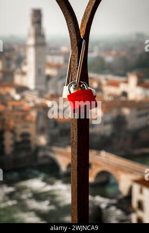 Punto panoramico della città di Verona. Una ringhiera, sigillata da un romantico lucchetto, incornicia il suo centro storico Foto Stock