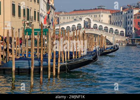 VENEZIA, ITALIA, 3 febbraio 2024: Stazione delle gondole sul Canal grande e sul ponte di Rialto. Il Canal grande forma uno dei principali corridoi di traffico d'acqua Foto Stock