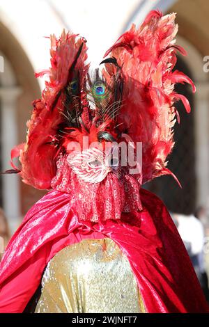 Venezia, VE, Italia - 13 febbraio 2024: Maschera veneziana di colore oro e rosso al Carnevale Foto Stock
