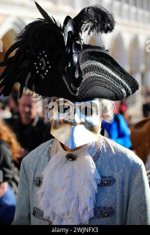 Venezia, VE, Italia - 13 febbraio 2024: Persona mascherata con grande rumore e cappello nero al Carnevale Foto Stock