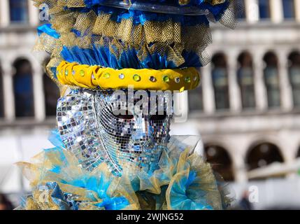 Venezia, VE, Italia - 13 febbraio 2024: Persona mascherata con volti pieni di specchi durante il carnevale veneziano Foto Stock