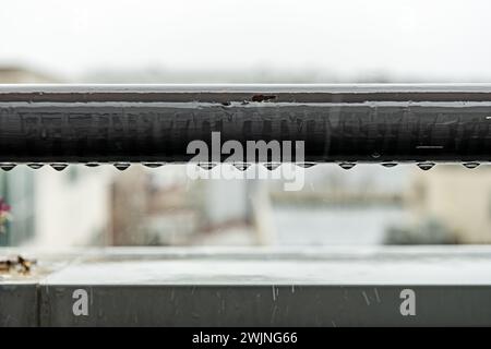 Ringhiera rotonda in metallo bagnata da gocce di pioggia intensa Foto Stock