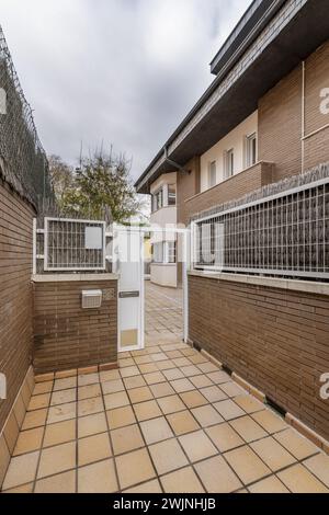 Accesso piastrellato a case unifamiliari semi-indipendenti costruite con mattoni marroni Foto Stock