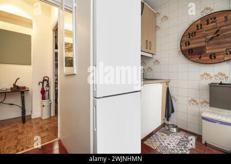 una cucina con mobili di legno chiaro, vari elettrodomestici e accesso ad una sala con pavimenti in parquet di quercia Foto Stock