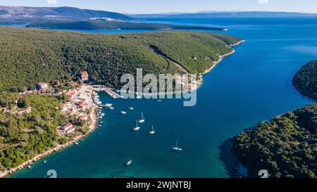 Una prospettiva aerea mozzafiato che mostra un lago tranquillo e maestose montagne nel villaggio di Krnica, nel sud-est dell'Istria, in Croazia Foto Stock