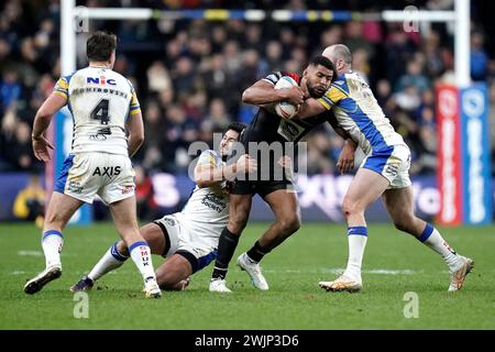 Kallum Watkins (centro) dei Salford Red Devils viene placcato durante il Betfred Super League match all'Headingley Stadium di Leeds. Data foto: Venerdì 16 febbraio 2024. Foto Stock