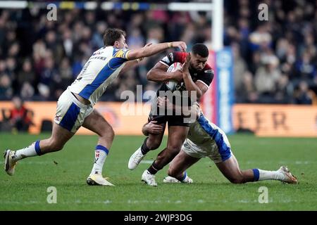 Il Kallum Watkins (centro) dei Salford Red Devils sfonda la difesa dei Leeds Rhinos durante la partita Betfred Super League all'Headingley Stadium di Leeds. Data foto: Venerdì 16 febbraio 2024. Foto Stock