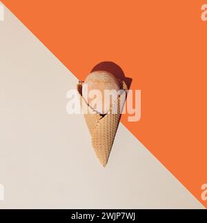 Cono gelato con frutta estiva congelata su sfondo arancio e beige. Concetto gastronomico estivo minimalista. Posizione piatta. Foto Stock