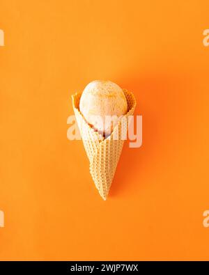 Coni di gelato con frutta estiva congelata sull'arancia. Concetto gastronomico estivo minimalista. Posizione piatta. Foto Stock