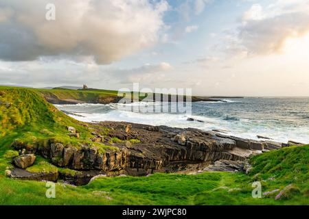 Famoso castello di Classiebawn nel pittoresco paesaggio di Mullaghmore Head. Spettacolare vista del tramonto con enormi onde che si infrangono a terra. Punto di firma di Wil Foto Stock