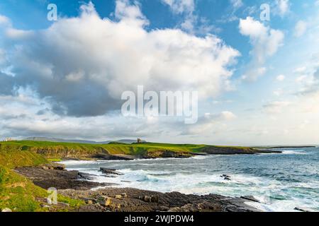 Famoso castello di Classiebawn nel pittoresco paesaggio di Mullaghmore Head. Spettacolare vista del tramonto con enormi onde che si infrangono a terra. Punto di firma di Wil Foto Stock