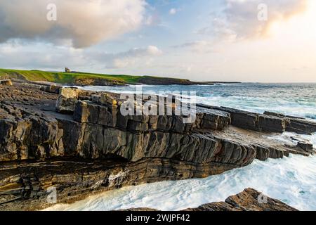 Famoso castello di Classiebawn nel pittoresco paesaggio di Mullaghmore Head. Spettacolare vista del tramonto con enormi onde che si infrangono a terra. Punto di firma di Wil Foto Stock