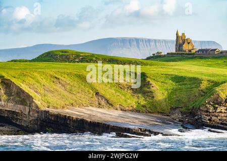 Famoso castello di Classiebawn nel pittoresco paesaggio di Mullaghmore Head. Spettacolare vista del tramonto con enormi onde che si infrangono a terra. Punto di firma di Wil Foto Stock